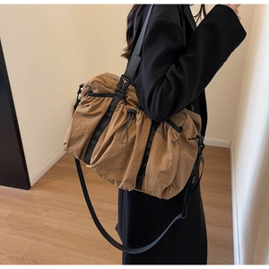 Detailansicht der khakifarbenen Reisetasche mit großem Fassungsvermögen am Modell getragen