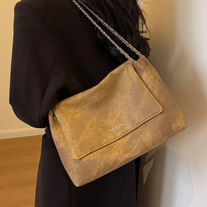 Brown leather tote bag with silver chain strap shown as a side-view shoulder bag