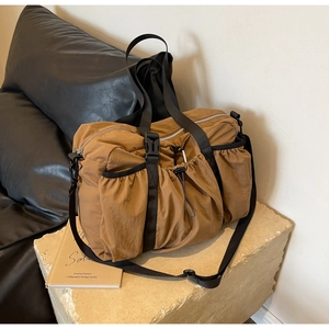 Detail der karamellfarbenen Nylon-Reisetasche mit Kordelzugtaschen und Tragegurten