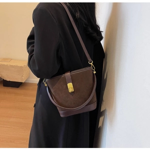 Vue détaillée d'un sac seau vintage en cuir marron mat avec boucle dorée élégante