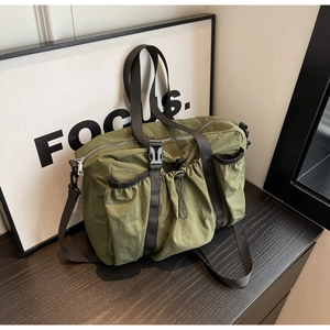 Detail der olivgrünen Nylon-Reisetasche mit Kordelzugtaschen und Schnallenverschluss