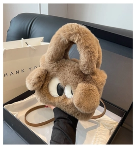 Detailed macro view of the fluffy brown plush handbag with cute eye designs in a gift box