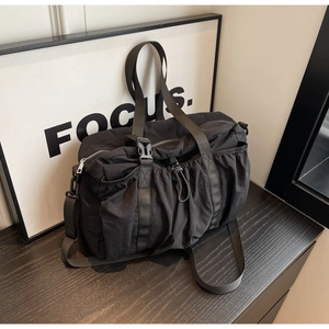 Detail der schwarzen Nylon-Reisetasche mit verstellbarer Schnalle und Kordelzug-Textur