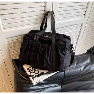 Detail der schwarzen Nylon-Reisetasche mit Falten-Design und verstellbarem Schultergurt
