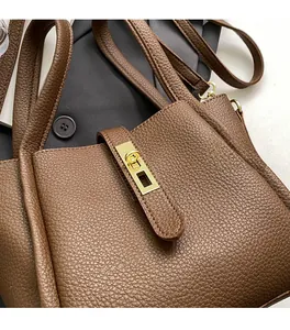Gros plan sur la texture en cuir marron et le fermoir doré d'un sac à main seau rétro