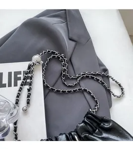 Detail of adjustable silver ball buckle and metal chain strap on black leather bag