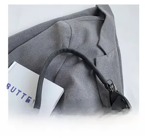 Close-up of matte black leather handbag shoulder strap with durable metal buckle hooks