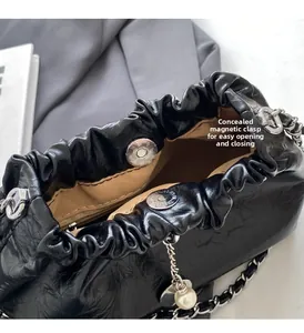 Detail shot of the black glossy bucket bag featuring an invisible magnetic buckle closure