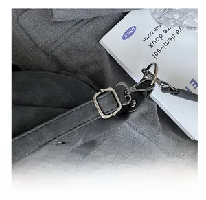 Detailed macro view of dark grey matte leather shoulder strap with gunmetal buckle and zipper