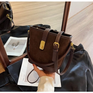 Détail du sac seau marron mat vintage avec boucle dorée et coutures en cuir