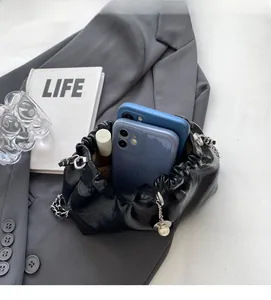 Internal view of black ruched bucket bag with silver chain, showing phone storage capacity