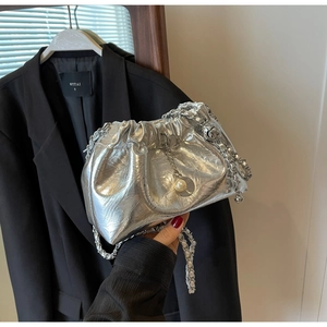 Detail of silver metallic ruched cloud bag with chain strap and pearl pendant