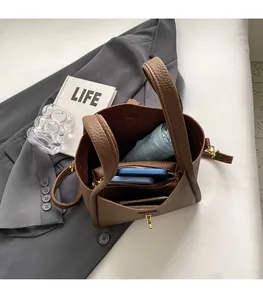 Détail du sac seau en cuir grainé caramel avec intérieur spacieux et fermoir doré chic