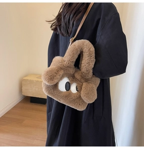 Detail of soft brown faux fur bag with cartoon eyes and leather shoulder strap