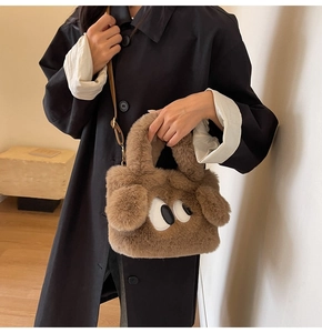 Detail of soft brown faux fur bag with cute cartoon eye embroidery and leather strap