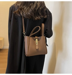 Détail du sac seau en cuir marron grainé avec boucle en métal doré et coutures précises