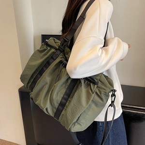 Olivgrüne Nylon Reisetasche mit verstellbarem Gurt von Model getragen im Zimmer
