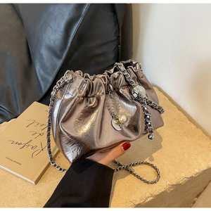 Detail of silver metallic cloud bag with chunky chain strap and pearl charm accents
