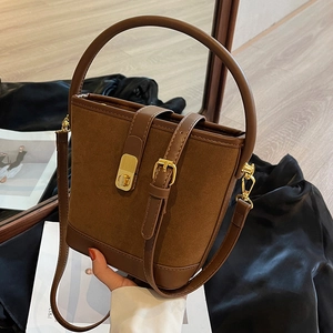 Sac seau vintage marron en daim avec coutures en cuir et fermoir doré en situation réelle