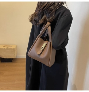 Détail du sac seau en cuir grainé marron foncé avec fermoir vertical en métal argenté