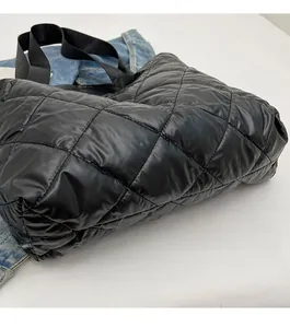 Detail view of quilted black tote bag showing durable stitching and smooth bottom design