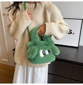 Detail of green fluffy plush handbag featuring cartoon eyes and thin shoulder strap