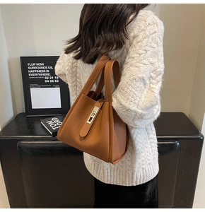 Détail du sac seau en cuir grainé marron avec fermoir métallique et doubles poignées