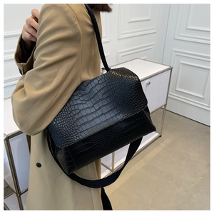 Gros plan sur la texture cuir crocodile noir d'un sac à bandoulière élégant pour femme