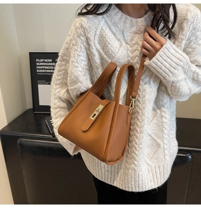 Détail du sac seau en cuir grainé marron avec fermoir métallique et bandoulière