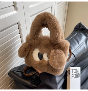 Close-up of the soft brown faux fur texture and cartoon eyes detail on the handbag