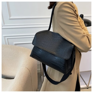 Détail de la texture crocodile noire d'un grand sac cabas avec bandoulière large
