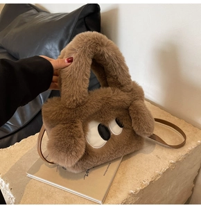 Close-up of soft brown plush dog handbag with long ears and detachable leather strap