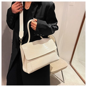 Détail du sac cabas blanc cassé à motif crocodile avec large bandoulière textile
