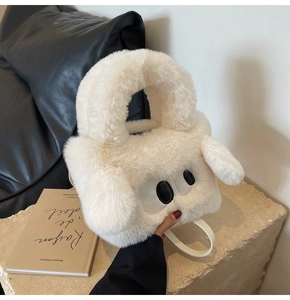 Close-up of white plush handbag with cute eyes detail on stone base background