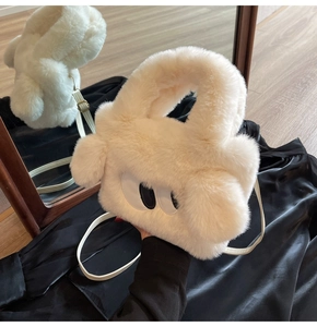 Detail of plush faux fur texture and cartoon eye design on the white crossbody handbag