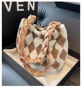 Detail of plush tote bag with checkered faux fur texture and woven leather handles
