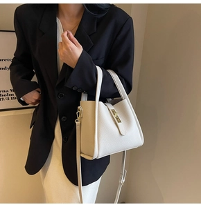 Détail d'un sac à main blanc en cuir grainé avec fermoir doré et bandoulière ajustable