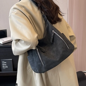 Deep grey matte tote bag with multi-zipper detail shown on shoulder in a lifestyle setting