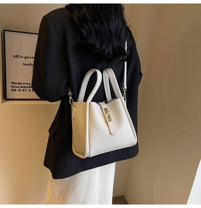 Détail du sac seau en cuir grainé crème avec fermoir rotatif doré et fine bandoulière