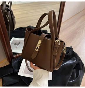 Gros plan d'un sac à main en cuir grainé marron avec fermoir doré et texture raffinée