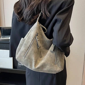 Large grey hobo bag with silver zippers and matte texture shown on a model for daily commute