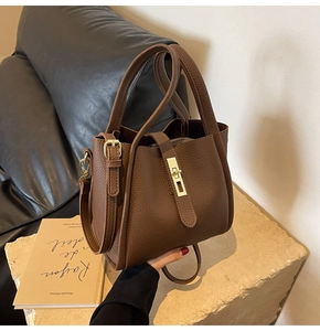 Détail du cuir grainé marron foncé avec fermoir pivotant en métal doré chic