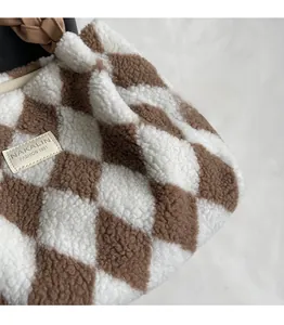 Detail of plush checkered tote bag featuring soft faux fur texture and woven handle