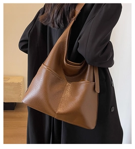 Détail du grand sac cabas en cuir marron à motif litchi avec deux poches avant spacieuses