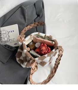 Detail view of large checkered plush tote bag interior with braided strap and daily items