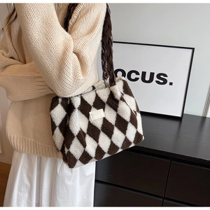 Detail of plush tote bag featuring brown and white lozenge patterns and woven strap