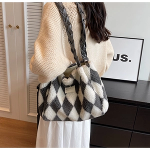 Detail of plush tote bag featuring grey plaid texture and braided leather handle straps