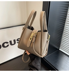 Détail du sac seau kaki en cuir grainé avec fermoir doré et deux poignées de transport