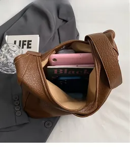 Vue de dessus du grand sac cabas en cuir grainé marron avec tablette et livres