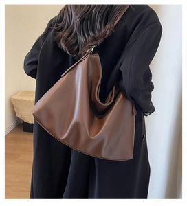 Close-up of the vintage brown leather tote bag showing fine texture and slouchy design